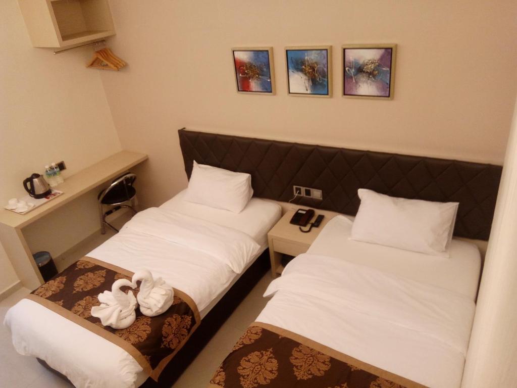 Postel nebo postele na pokoji v ubytování Golden Leaves Hotel