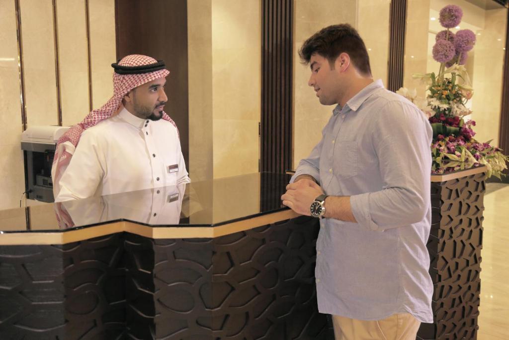 two men standing in front of a counter at Saja Al Madinah in Al Madinah