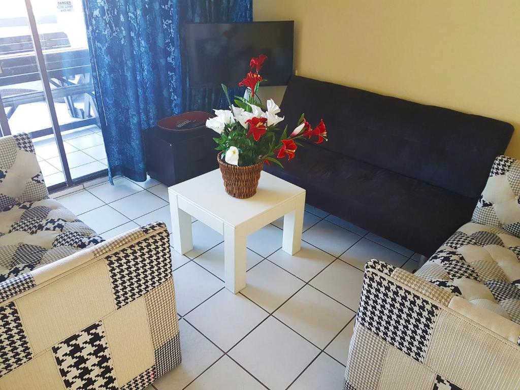 una sala de estar con una mesa con flores. en Dumela Margate Flat No 22, en Margate