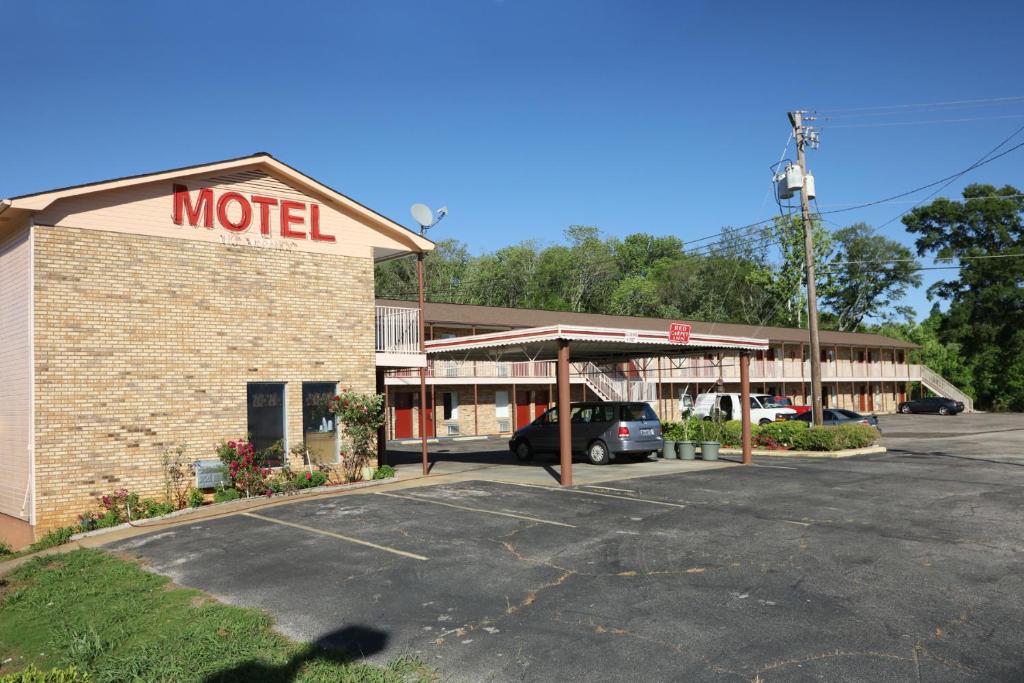 a motel with a car parked in a parking lot at Red Carpet Inn Oxford in Oxford