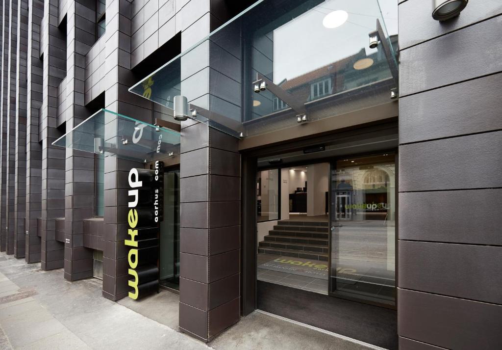 a store front with a sign on the side of a building at Wakeup - Aarhus in Aarhus
