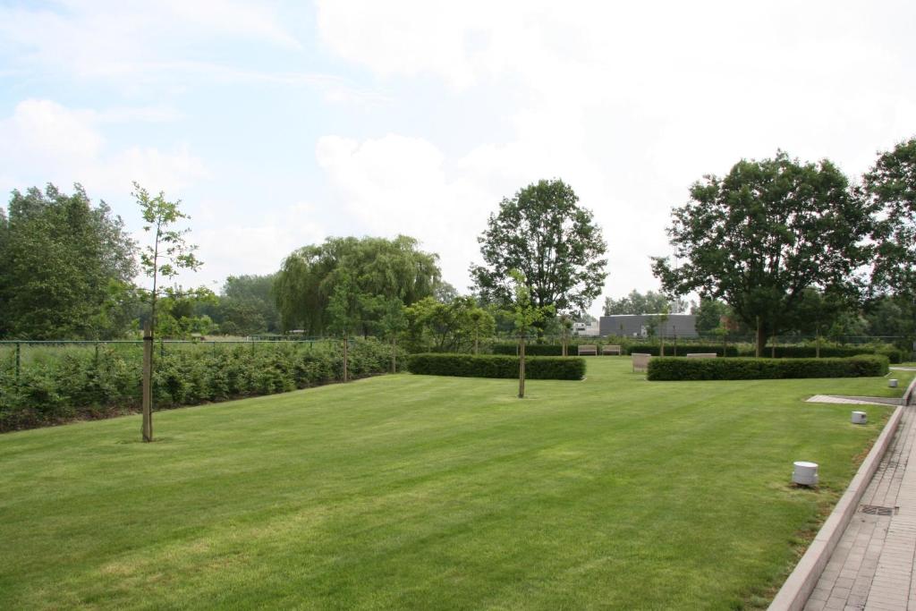 a large field of grass with trees and bushes at Biznis Hotel in Lokeren