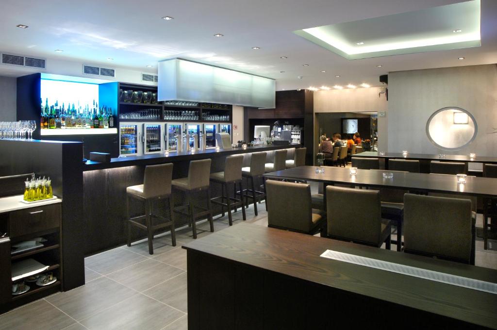 a bar in a restaurant with chairs and tables at Biznis Hotel in Lokeren