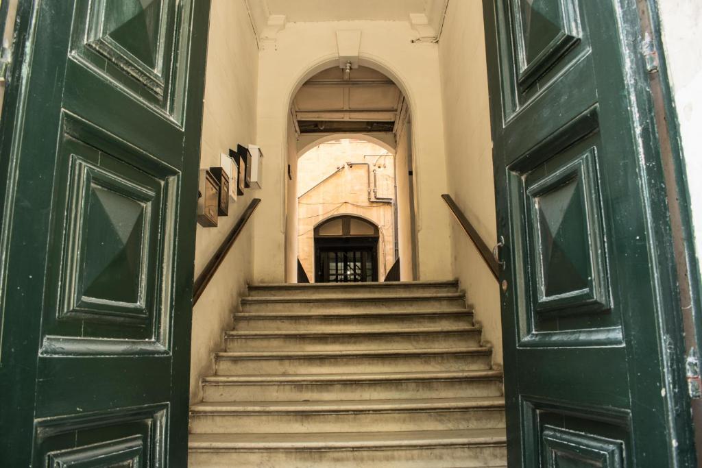 an entrance to a building with a green door and stairs at Vincenti Strait Street Suite in Valletta