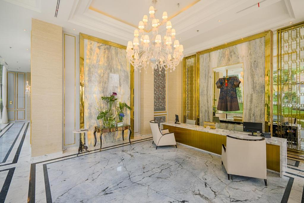 a lobby with a chandelier and a table and chairs at Art Deco Luxury Hotel & Residence in Bandung