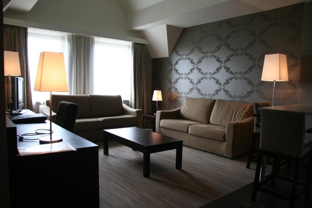 a living room with a couch and a table at Biznis Hotel in Lokeren