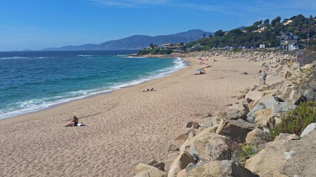 a group of people on a beach near the ocean at Residence ACQUA LINDA Porticcio in Porticcio