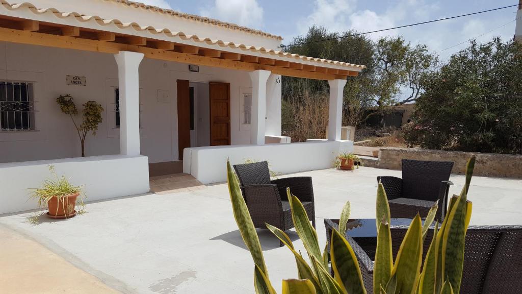 a patio with two chairs and a house at Can Angel in Sant Francesc Xavier