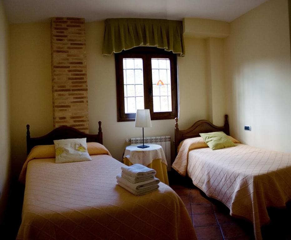 - une chambre avec 2 lits et une fenêtre dans l'établissement Casas Rurales Canserta, à Alcaraz