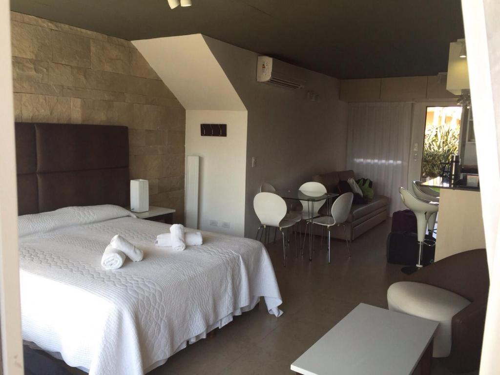 Un dormitorio con una cama blanca con toallas blancas. en Linda Bay spa playa Unidad 603 Mar de Las Pampas, en Mar de las Pampas
