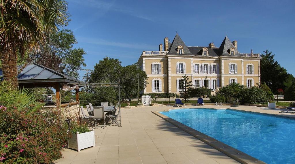 een groot huis met een zwembad ervoor bij Chambres d'hotes de Pouzelande in Notre-Dame-de-Sanilhac