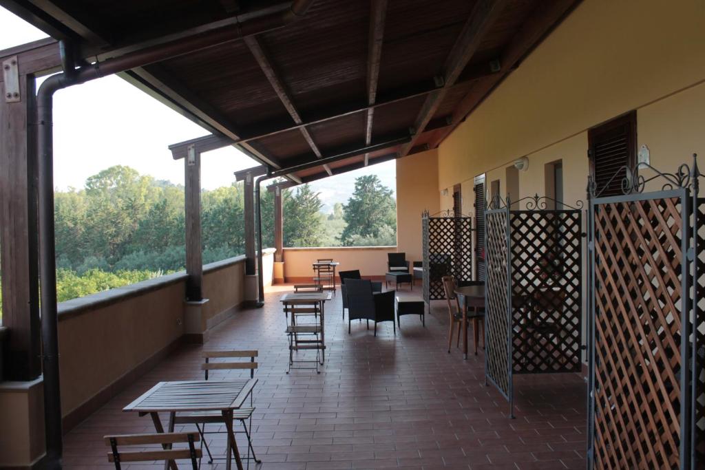 a restaurant with tables and chairs and a patio at Agriturismo L'Assiolo in Miglionico