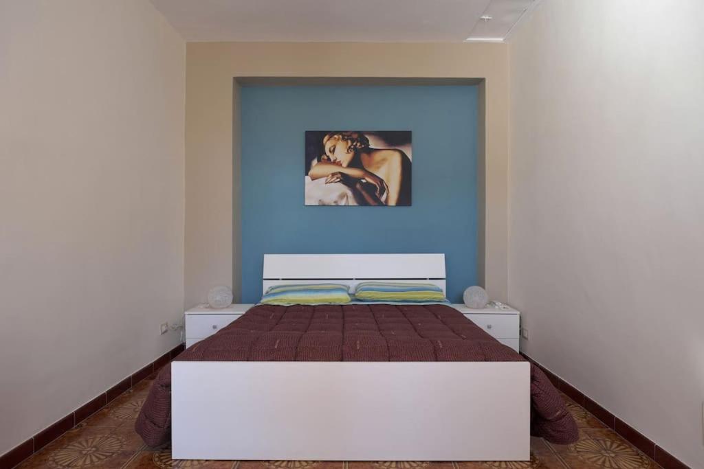 - une chambre avec un lit orné d'une peinture murale dans l'établissement La Tana del Lupo, à San Giovanni Gemini
