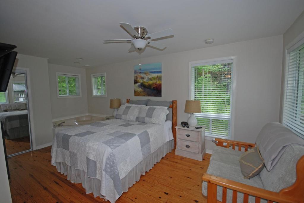 ein Schlafzimmer mit einem Bett, einem Sofa und Fenstern in der Unterkunft Ogopogo Resort in Carnarvon