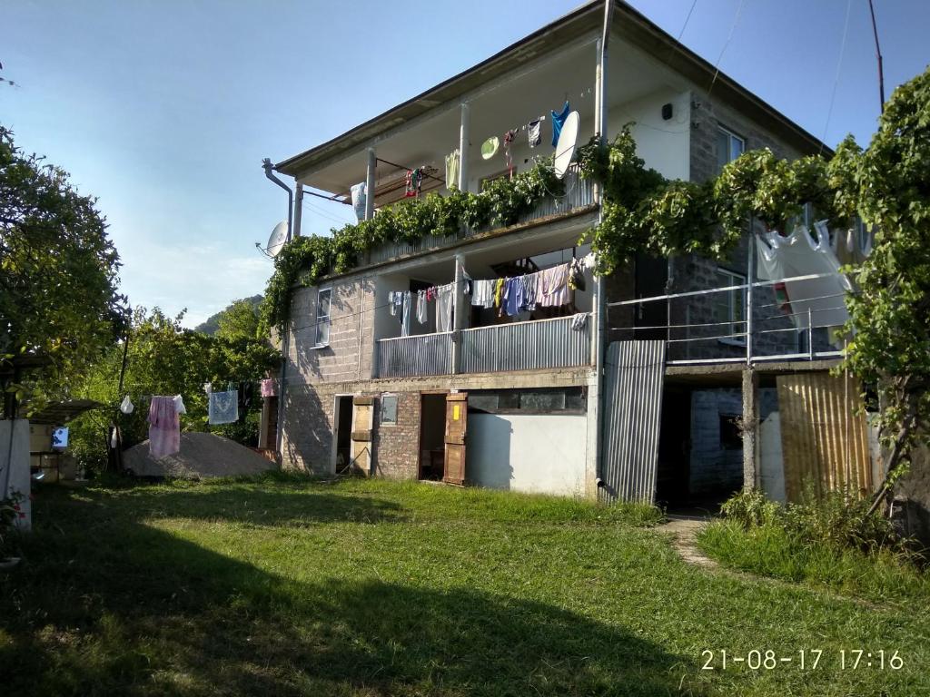 un edificio de apartamentos con ropa colgada en un balcón en Частный дом en Novy Afon
