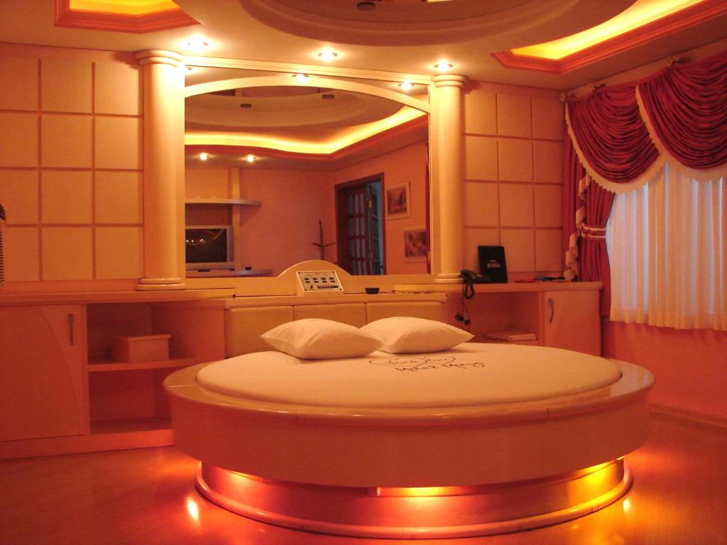 Zimmer mit einem Bett vor einem Spiegel in der Unterkunft Motel Monza (Adults Only) in Farroupilha
