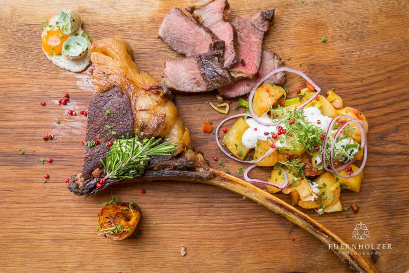 una comida de carne y verduras en una mesa de madera en Gasthof Post en Sankt Gallen