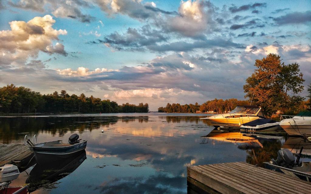 two boats are docked at a dock on a lake at Sunrise Resort in Buckhorn