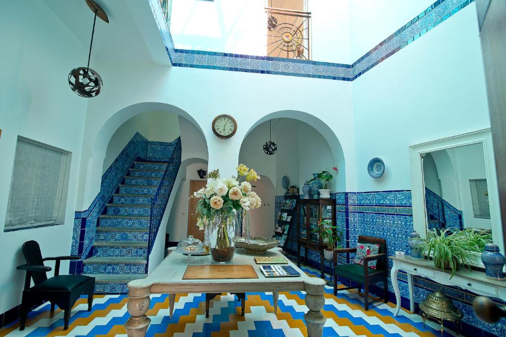 una habitación con una mesa con un jarrón de flores en Hostal Casa Alborada en Conil de la Frontera