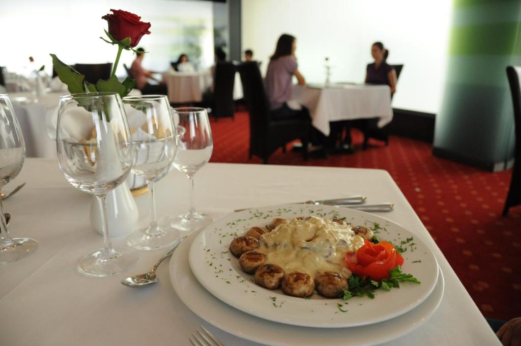 a plate of food on a table with wine glasses at Hotel EMD in Bacău