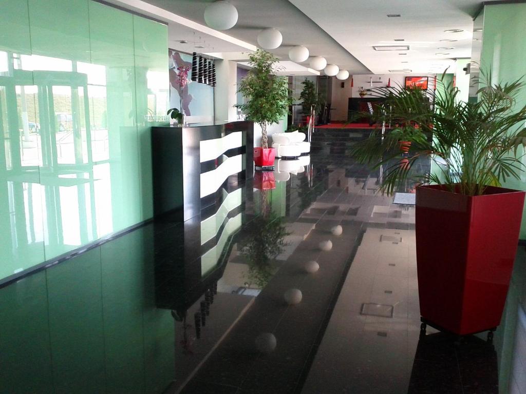 a lobby with potted plants in a building at Hotel EMD in Bacău