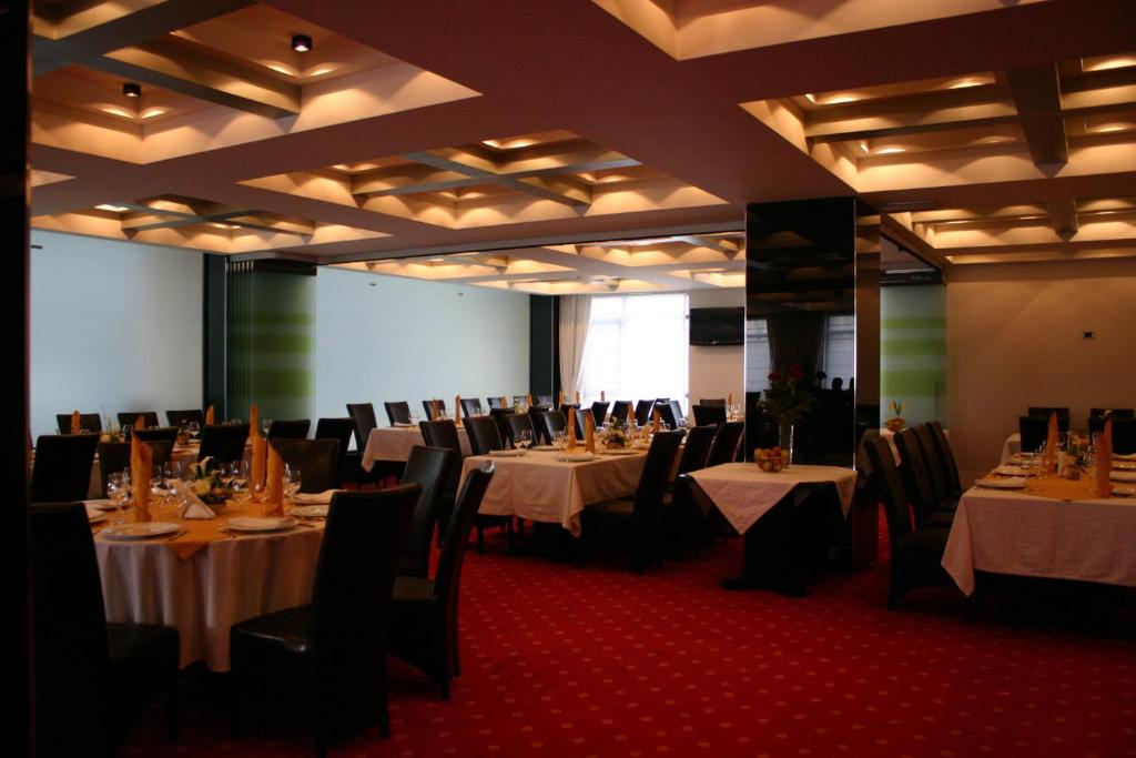 a banquet hall with tables and chairs with white table cloth at Hotel EMD in Bacău