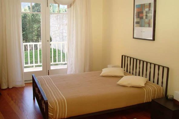 Ce lit se trouve dans une chambre dotée d'une grande fenêtre. dans l'établissement Quinta das Mineirinhas, à Vila Nova de Cerveira