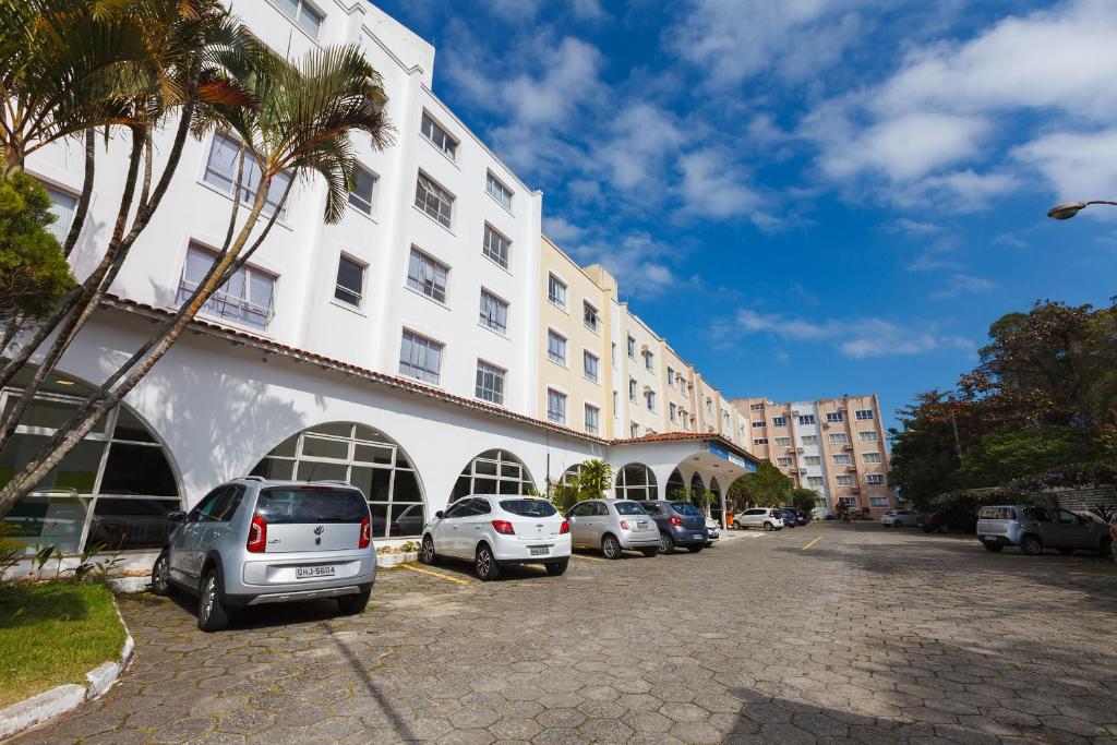 un groupe de voitures garées devant un bâtiment dans l'établissement Tri Hotel Florianópolis, à Florianópolis