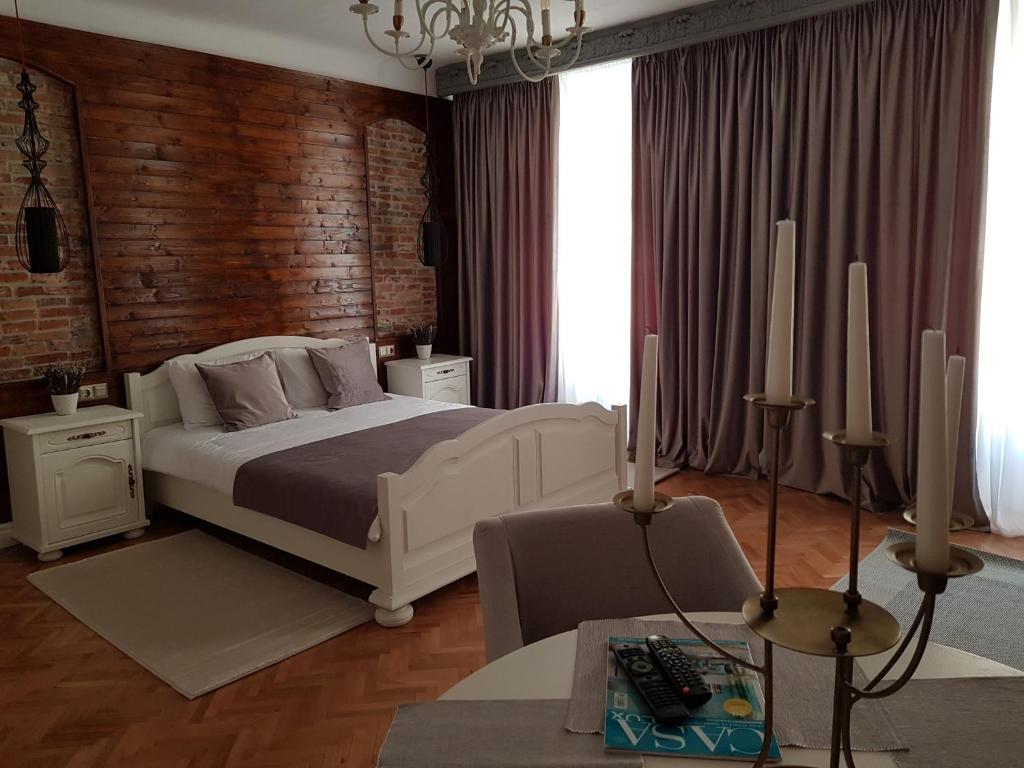 シビウにあるAlfa Studioの白いベッドとレンガの壁が備わるベッドルーム1室が備わります。
