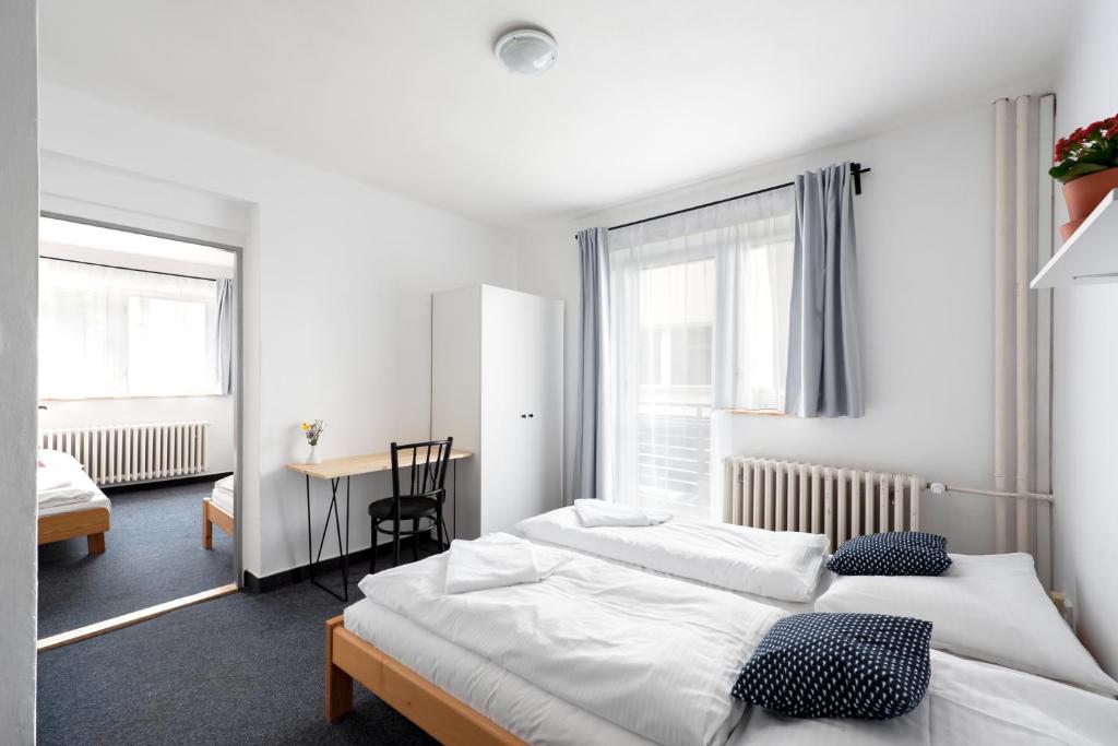 a hotel room with two beds and a desk at Hotel Horní Pramen in Špindlerův Mlýn