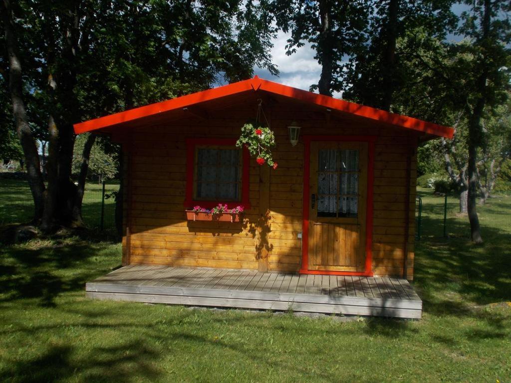 a small house with a porch and a window at Ula-Hansu talu in Suur-Rootsi