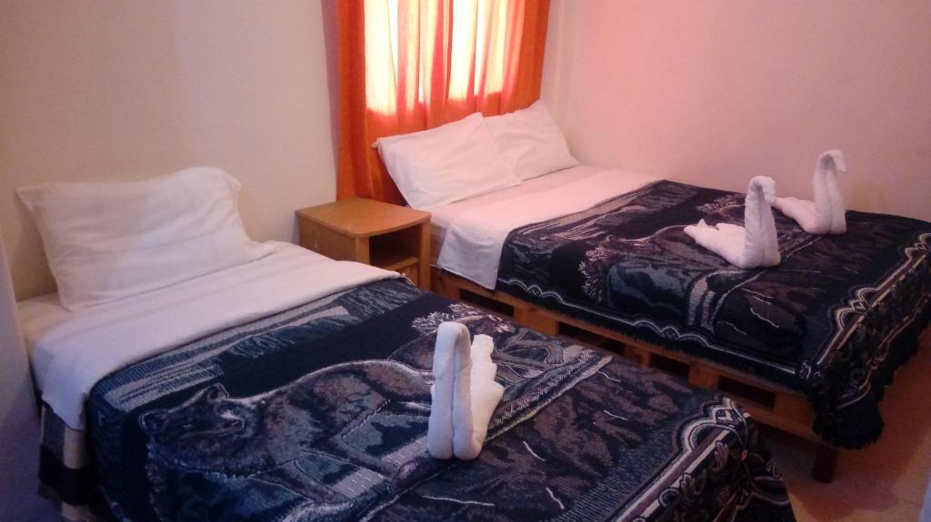 two beds with bunny feet on them in a room at Hotel Patria in Mexico City