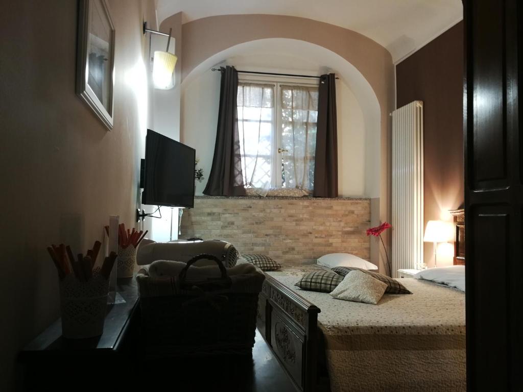 a bedroom with a bed and a window and a television at B&B Cascina Barolo in Turin