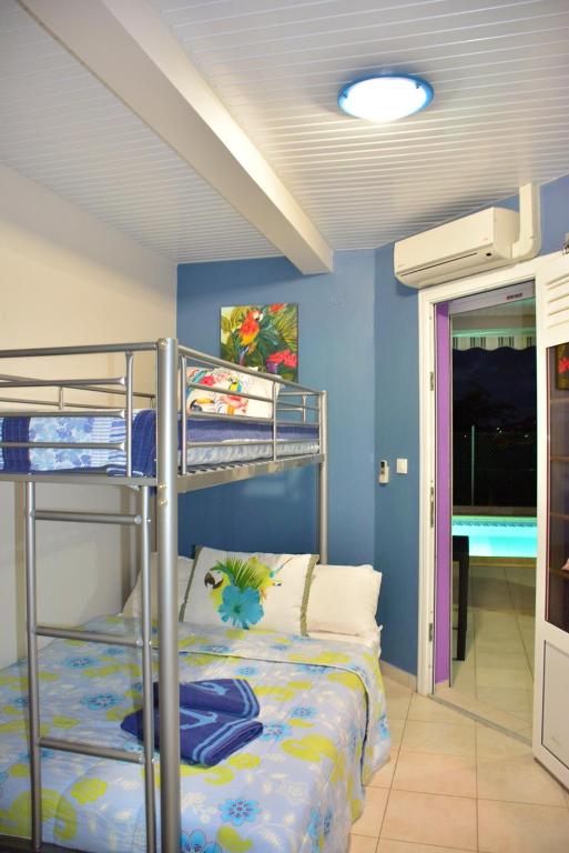 una camera con letto a castello di Villa Améthyste avec grande piscine privée, jardin clos, parking privé a Le Robert