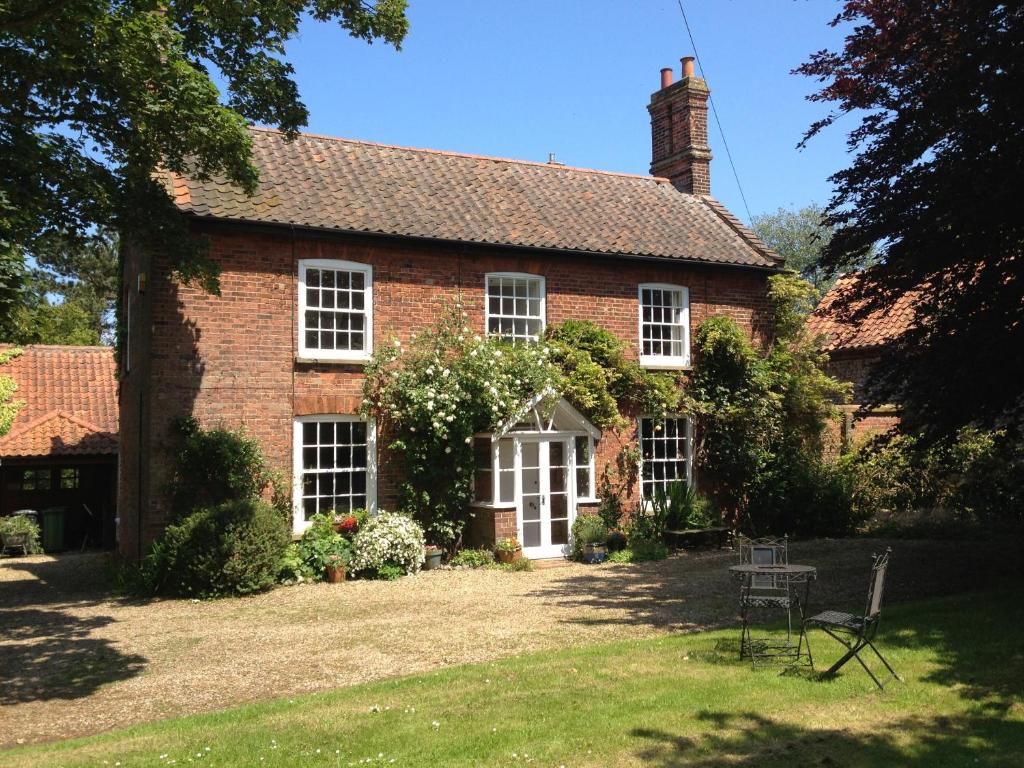 una antigua casa de ladrillo rojo con ventanas blancas en Mill House Bed and Breakfast, en Cromer