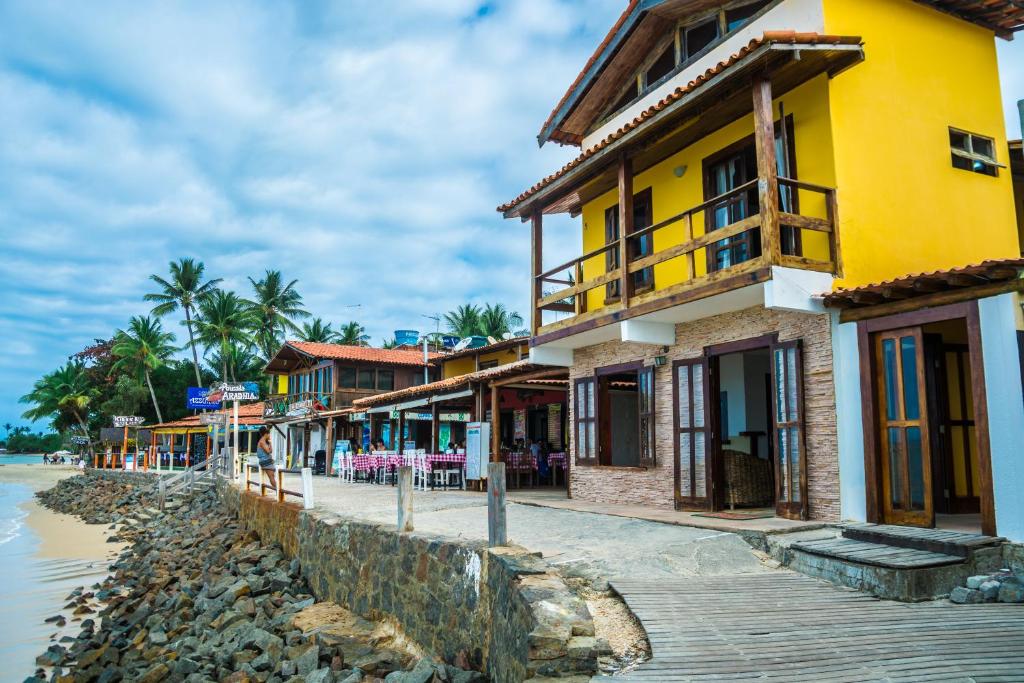 a row of houses on the shore of a beach at Pousada Grauçá in Morro de São Paulo