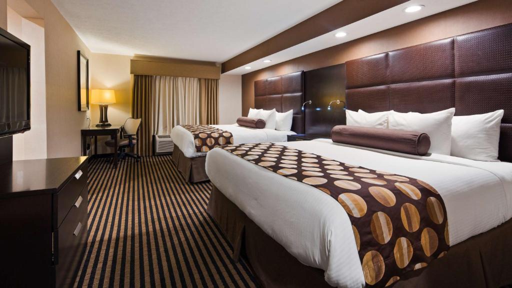 Una habitación de hotel con dos camas y un televisor. en Sonesta Essential Indianapolis Airport, en Plainfield