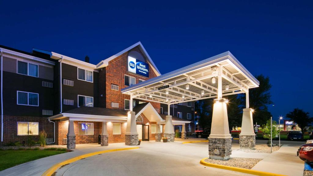 um edifício de hotel com um parque de estacionamento iluminado em Best Western Harvest Inn & Suites em Grand Forks