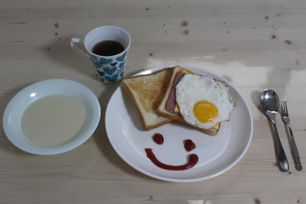 a plate of toast with an egg and a cup of coffee at Dadam Guesthouse in Yeosu