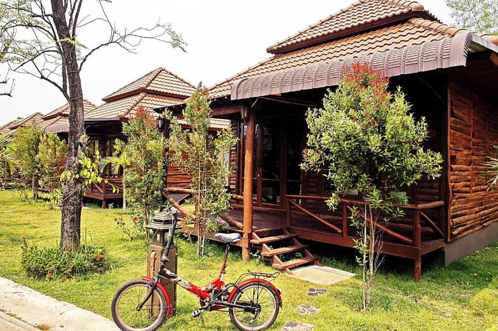 una bicicleta roja estacionada frente a una cabaña en Indie House @ Maerim, en Mae Rim