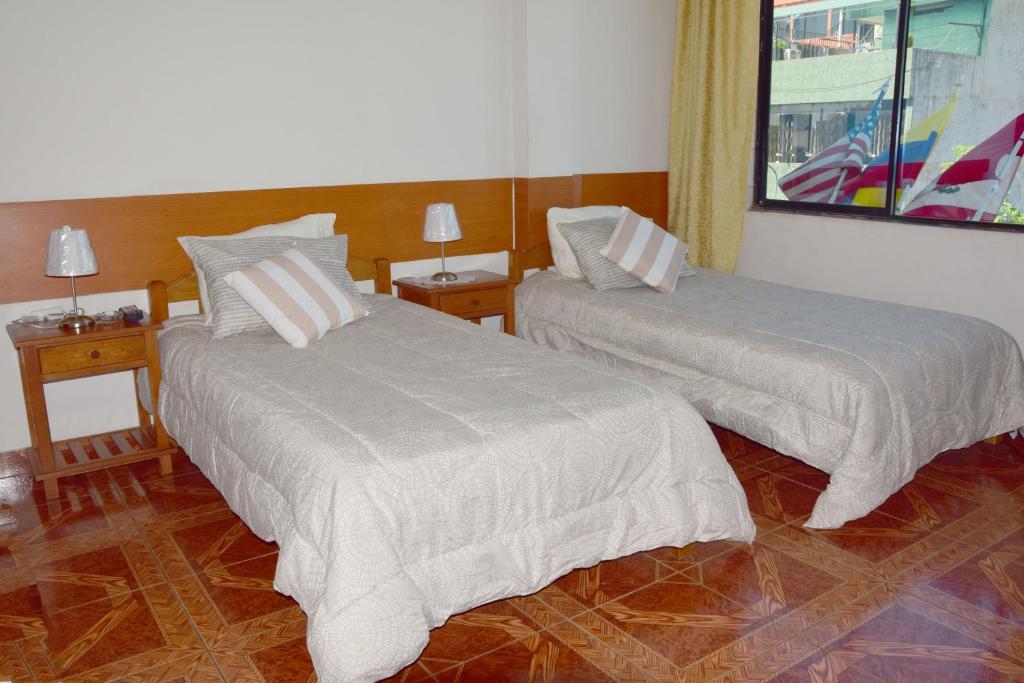 um quarto com duas camas e duas mesas com candeeiros em Casa del Huesped - Guest House em Pucallpa