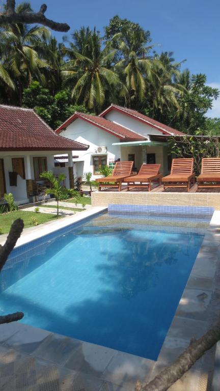a large swimming pool in front of a house at Sammy Homestay in Kuta Lombok
