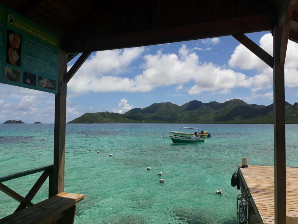 a boat in the water next to a dock at Posada Miss Portia in Providencia