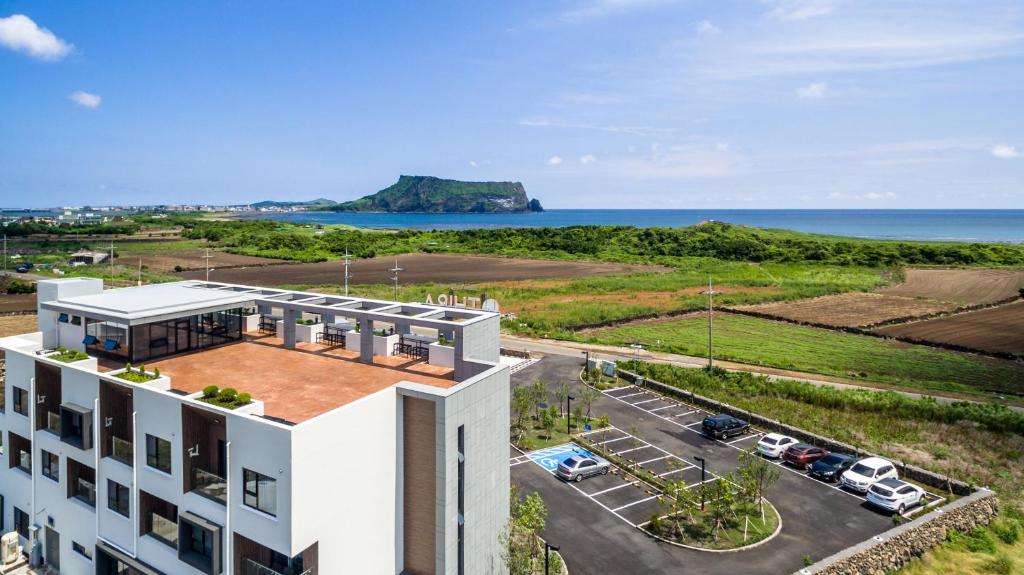 eine Luftansicht eines Gebäudes mit Meerblick im Hintergrund in der Unterkunft Thira Hotel in Seogwipo