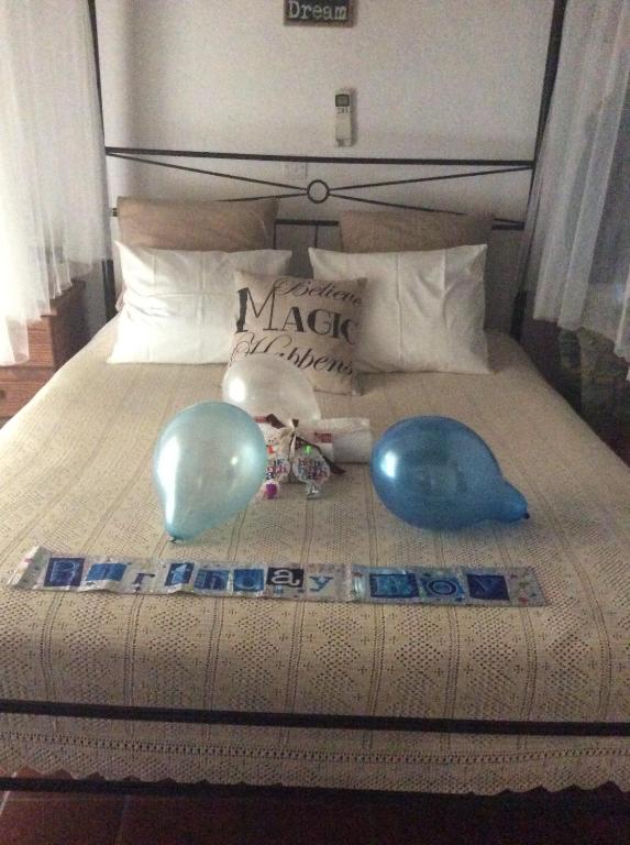 a bed with two blue balloons on it at Irene's House in Kakopetria