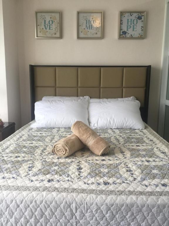 un asciugamano arrotolato, poggiato sopra un letto di Blissful Hill Tagaytay Condotel with Netflix a Tagaytay