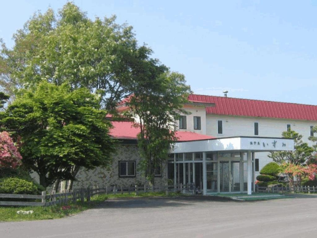 un gran edificio blanco con techo rojo en Hotel Izumi, en Shiraoi