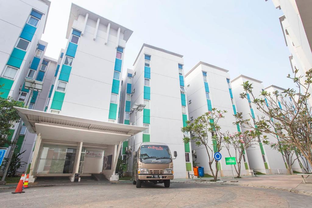 un camión estacionado frente a un edificio en De Green Inn @aeropolis en Tangerang