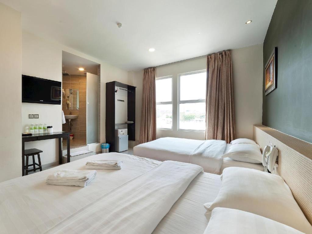 a hotel room with two beds and a window at One Avenue Hotel in Petaling Jaya