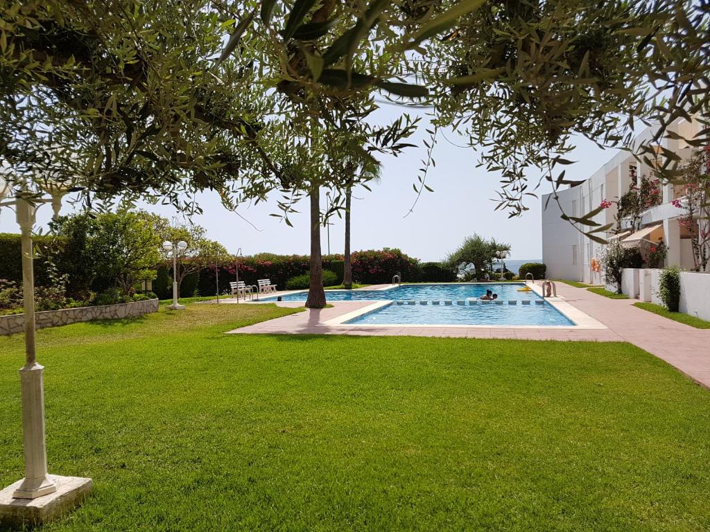 una piscina en un patio con césped verde en Apartamento en Vinaroz en Vinarós
